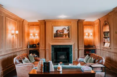 a living room with wooden walls and a fireplace at Three Cocks Hotel in Brecon