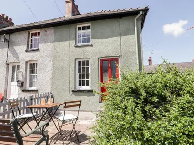 a house with a table and chairs in front of it at Kooky Cottage in Brecon