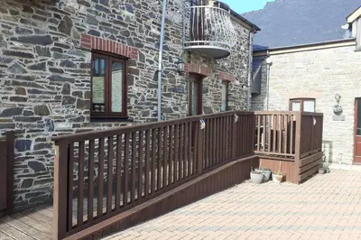 a wooden deck in front of a stone house at The Stable in Aberystwyth