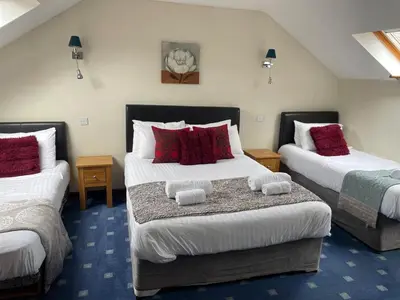 a bedroom with two beds with red and white pillows at The Stable in Aberystwyth