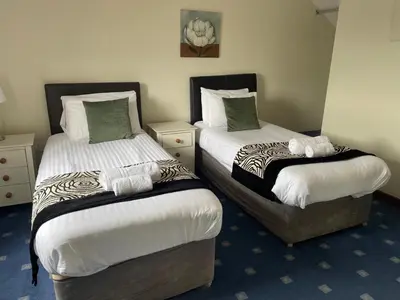 two beds in a hotel room withskirts at The Stable in Aberystwyth