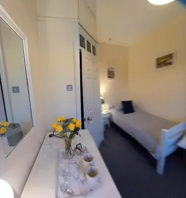 a room with a table with a vase of flowers on it at 2 Bodwen Villas in Llangollen