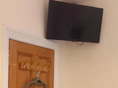 a flat screen tv hanging on a wall next to a door at 2 Bodwen Villas in Llangollen
