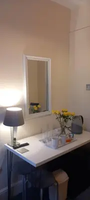 a table with a lamp and flowers on it at 2 Bodwen Villas in Llangollen
