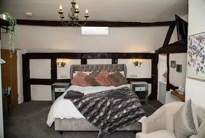 a bedroom with a large bed with a wooden headboard at The Yew Tree Inn in Church Stretton