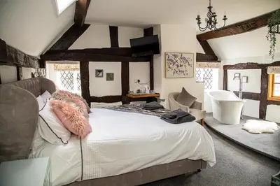 a bedroom with a large bed and a sink at The Yew Tree Inn in Church Stretton