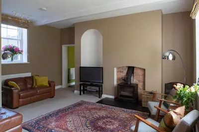 a living room with a couch and a fireplace at Henley Hall, Ludlow in Ludlow