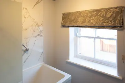 a bathroom with a tub and a window and a sink at Henley Hall, Ludlow in Ludlow