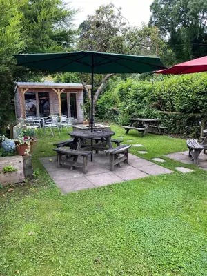 a picnic table with an umbrella in the grass at Old New Inn, Llanfyllin in Llanfyllin