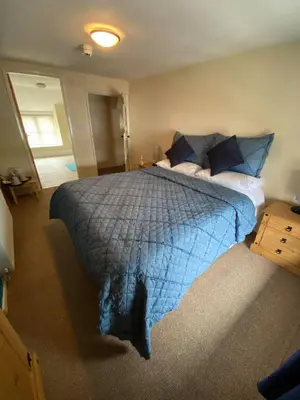 a bedroom with a large bed with a blue comforter at Old New Inn, Llanfyllin in Llanfyllin