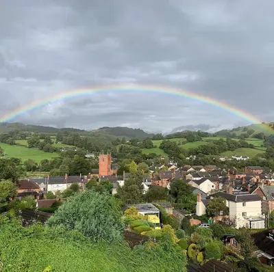 a rainbow over a town with a city at Old New Inn, Llanfyllin in Llanfyllin