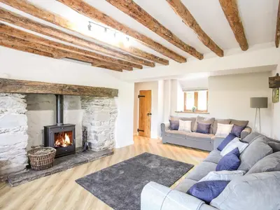 a living room with a couch and a fireplace at Hafotty Gelynen in Corwen