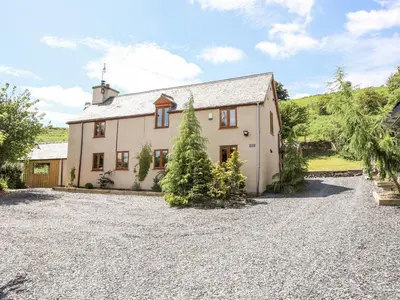 an exterior view of a house with a gravel driveway at Hafotty Gelynen in Corwen