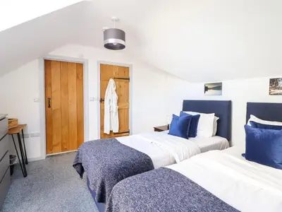 two beds in a room with blue and white at Y Stabl The Stable in Oswestry