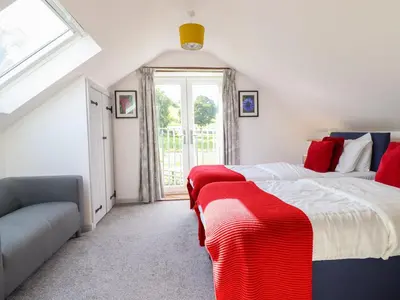 a bedroom with two beds and a window at Y Stabl The Stable in Oswestry