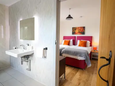a bathroom with a bed and a sink in a room at Y Stabl The Stable in Oswestry