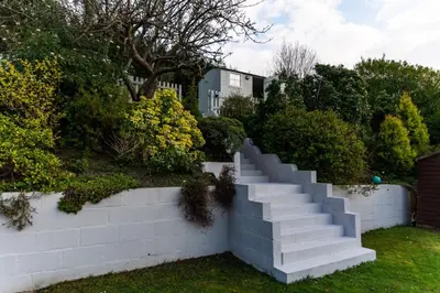 a set of stairs in a yard next to a wall at Hilltop Hut in Church Stretton