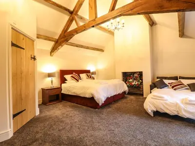 a large bedroom with two beds and a fireplace at Bodaioch Hall in Caersws