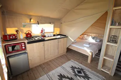 a room with a kitchen and a bed in a tent at Safari Tent with Hot Tub in heart of Snowdonia in Dolgellau