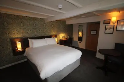 a bedroom with a large white bed and a desk at rooms @ the dolau inn in New Quay