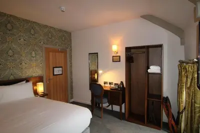 a hotel room with a bed and a desk and a bed and a desk at rooms @ the dolau inn in New Quay