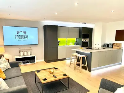 a living room with a couch and a kitchen at Apartment Twelve in Shrewsbury