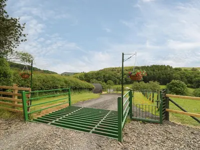a green gate with a swing on a dirt road at Seren in Llandrindod Wells