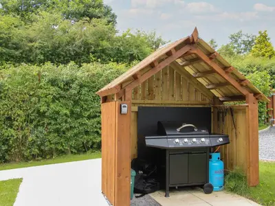 a barbecue oven in a wooden shed at Jacob's Meadow Pod 2 in Shrewsbury