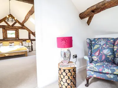a room with a chair and a bedroom at Swallows Rest in Montgomery