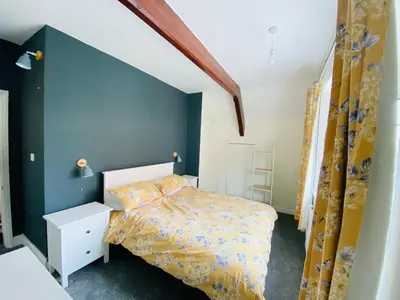 a bedroom with a bed and a blue wall at Ravelstone in Church Stretton