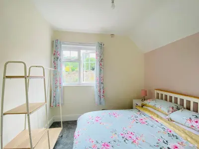 a bedroom with a bed and a window at Ravelstone in Church Stretton