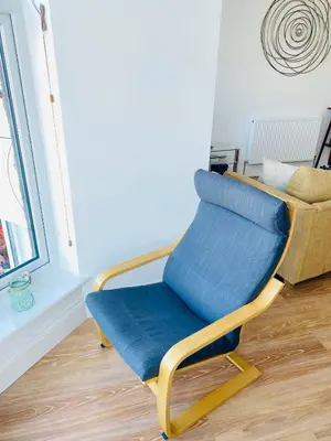 a blue chair sitting in a room next to a window at Bellaview Apartment Barmouth in Barmouth