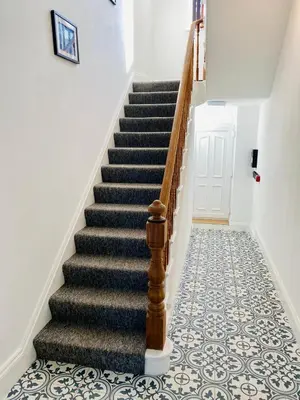 a hallway with a staircase with a tile floor at Bellaview Apartment Barmouth in Barmouth