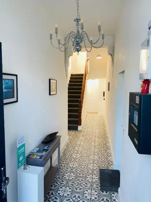 a hallway with a staircase and a chandelier at Bellaview Apartment Barmouth in Barmouth