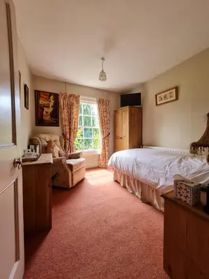 a bedroom with a bed and a couch and a window at The Old Vicarage in Shrewsbury