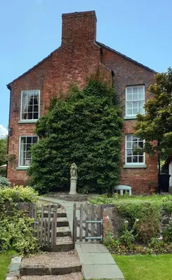 a brick building with a statue in front of it at The Old Vicarage in Shrewsbury