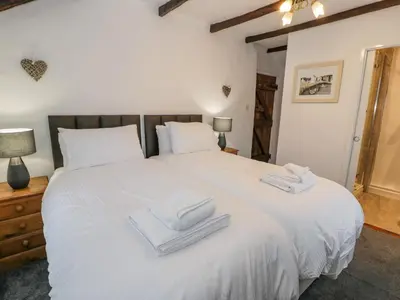 a bedroom with a large white bed with towels on it at Cae Lleci in Dolgellau