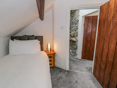a bedroom with a bed and a wooden door at Cae Lleci in Dolgellau