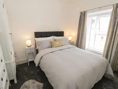 a bedroom with a large white bed and a window at Minffordd in Blaenau-Ffestiniog