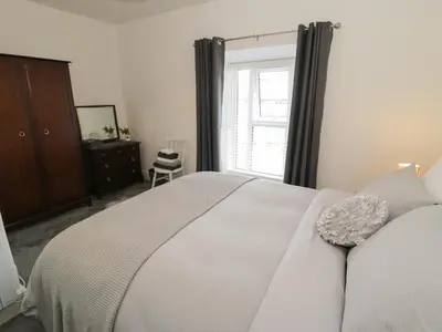 a bedroom with a white bed and a window at Minffordd in Blaenau-Ffestiniog