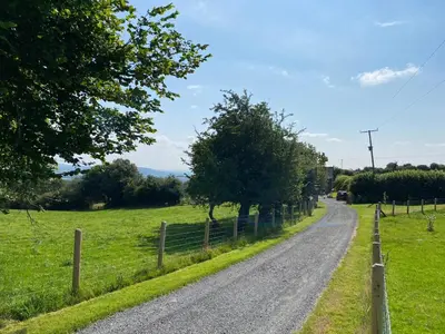 a dirt road in a field with a fence at The Retreat in Bredwardine