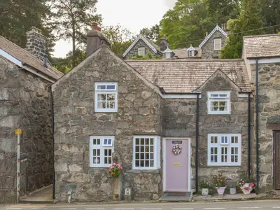 an old stone house with a pink door at The Toll House in Dolgellau