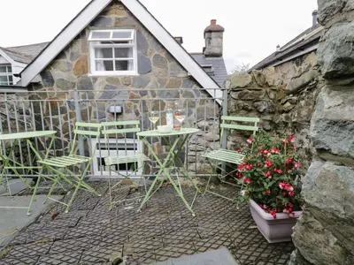 a patio with chairs and tables and a building at The Toll House in Dolgellau