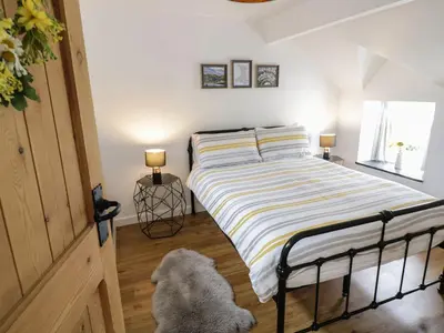 a bedroom with a bed and a dog on the floor at The Toll House in Dolgellau