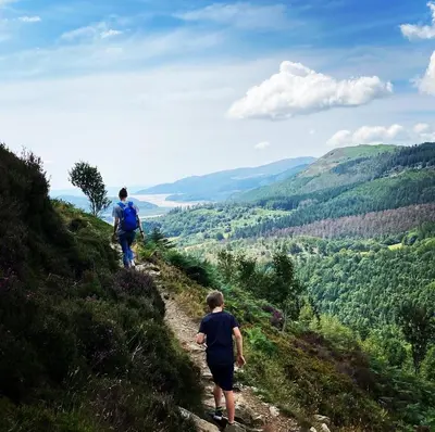two people walking up a hill on a trail at Ty Gles in Derwenlas