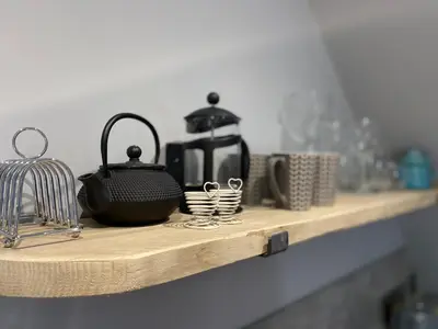a shelf with a coffee pot and cups on it at Ty Gles in Derwenlas
