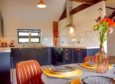 a kitchen with blue cabinets and a table with chairs at Hayes Suite in Oswestry