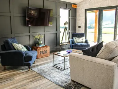 a living room with two couches and a tv at Meadow View in Meifod