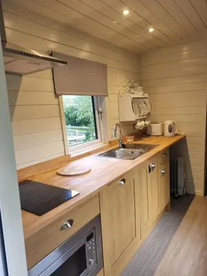 a kitchen with a sink and a window in a trailer at Glamping Hut - Sleeps 2 hot tub & parking in Welshpool