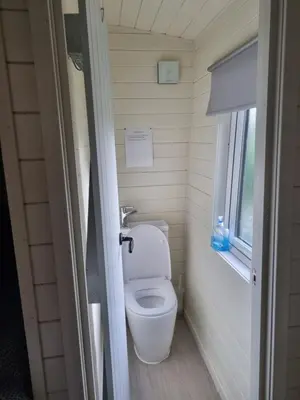 a toilet in a small bathroom with a window at Glamping Hut - Sleeps 2 hot tub & parking in Welshpool